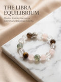 The Libra Luminary crystal bracelet with clear quartz 
rose quartz smoky quartz green phantom and tiger's eye beads, 
Libra zodiac healing jewelry on cream marble surface