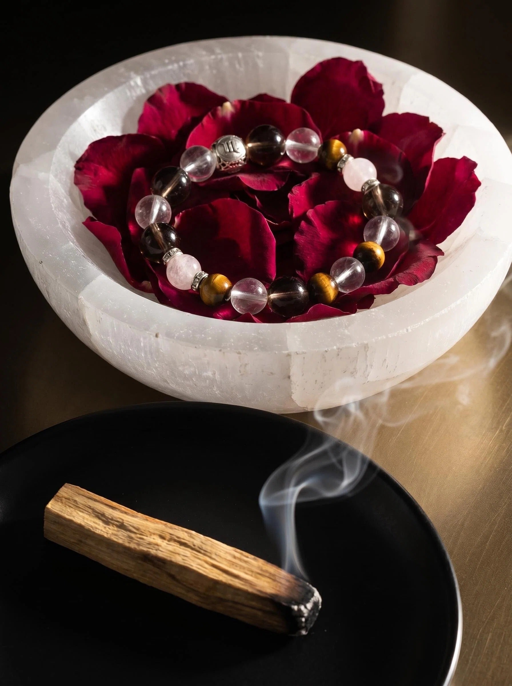 Scorpio Sovereign crystal bracelet on selenite charging plate 
with palo santo and clear quartz, 
scorpio zodiac crystal cleansing ritual