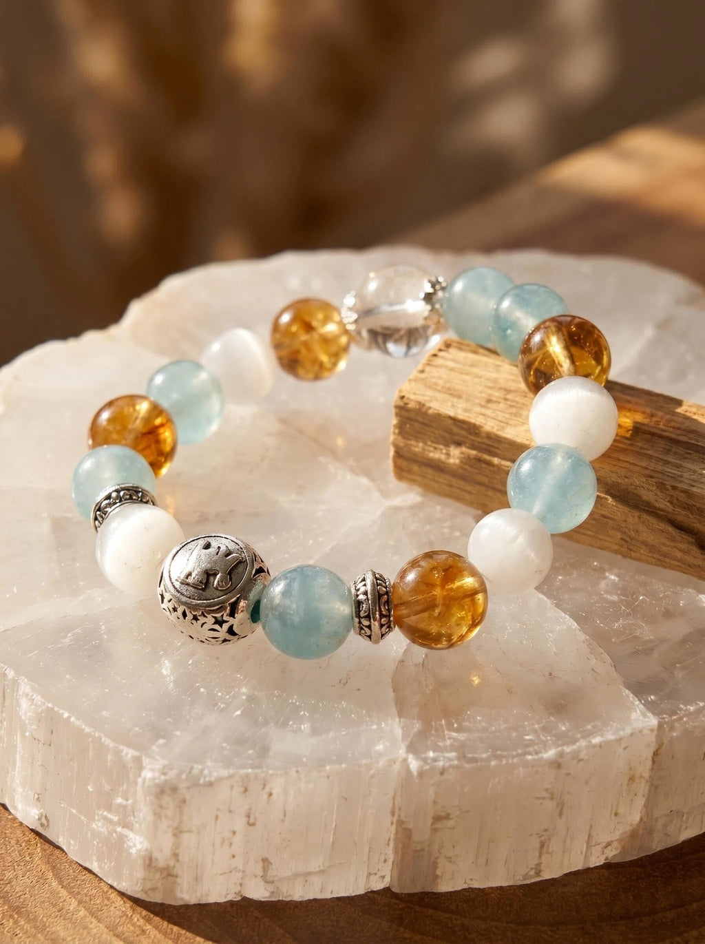 Taurus Throne crystal bracelet on selenite charging plate 
with palo santo and gold rutilated quartz point, 
taurus zodiac crystal cleansing ritual