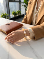 Woman's wrist wearing Golden Drift crystal bracelet
with yellow fluorite and white phantom quartz beads,
warm golden light lifestyle photography
wealth manifestation crystal jewelry