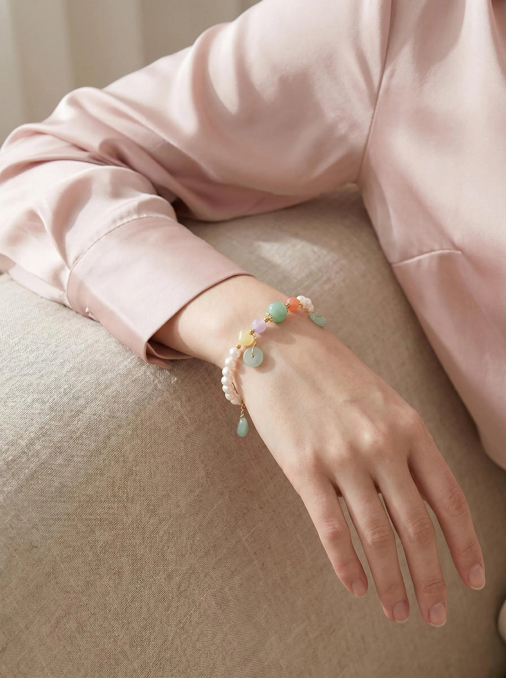 Woman's wrist wearing Pearl & Bloom crystal bracelet
with Swarovski pearl and strawberry quartz beads,
soft elegant lifestyle photography
heart chakra grace crystal jewelry