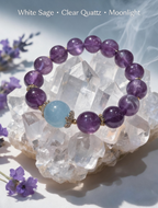 Amethyst and aquamarine bracelet resting on a selenite cleansing plate with palo santo smoke
