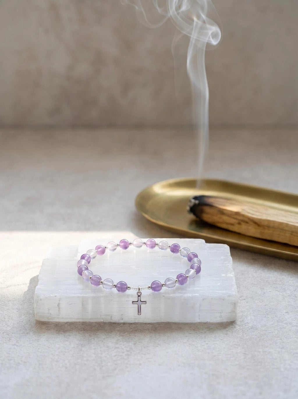 Sacred Light amethyst and grey moonstone bracelet
on selenite charging plate with palo santo,
divine protection crystal bracelet cleansing ritual
purple and silver tones