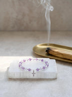 Sacred Light amethyst and grey moonstone bracelet
on selenite charging plate with palo santo,
divine protection crystal bracelet cleansing ritual
purple and silver tones