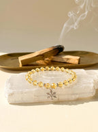 Solar Guardian pure lemon citrine bracelet
on selenite charging plate with palo santo,
citrine crystal bracelet cleansing ritual golden tones