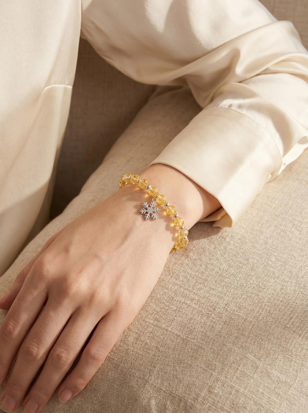 Woman's wrist wearing Solar Guardian
pure lemon citrine crystal bracelet,
warm golden light lifestyle photography,
wealth abundance crystal jewelry