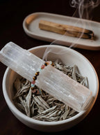 Vitality Grace crystal bracelet on selenite charging plate 
with white sage and crystal cluster, 
7-stone crystal bracelet cleansing ritual