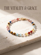 The Vitality Grace crystal bracelet with strawberry quartz 
kyanite yellow tiger's eye aquamarine clear quartz 
yellow topaz and red agate beads, 
7-stone vitality healing bracelet on white marble surface
