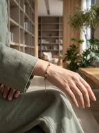 Woman's wrist wearing Vitality Grace 7-stone crystal bracelet 
with strawberry quartz and kyanite beads, 
warm lifestyle photography magnetic presence aesthetic