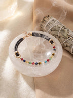 Vitality Grace pet collar on selenite charging plate 
with white sage bundle and crystal cluster, 
crystal pet collar cleansing ritual soft tones