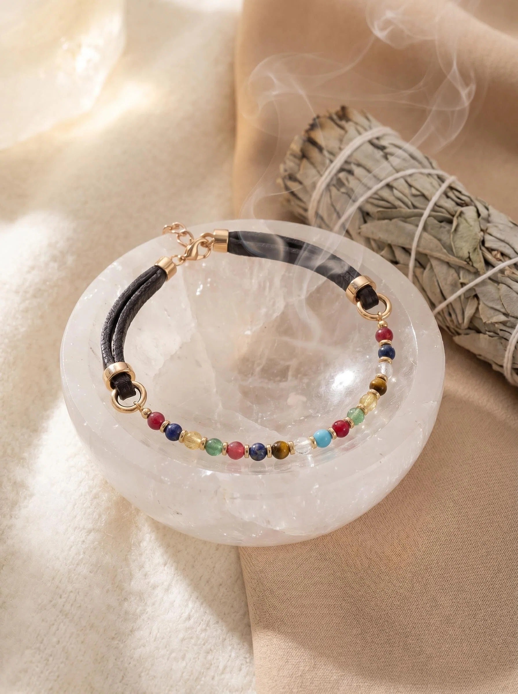 Vitality Grace pet collar on selenite charging plate 
with white sage bundle and crystal cluster, 
crystal pet collar cleansing ritual soft tones