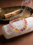 Warm Light crystal bracelet on selenite charging plate
with palo santo smoke and amber piece,
crystal bracelet cleansing ritual warm golden tones